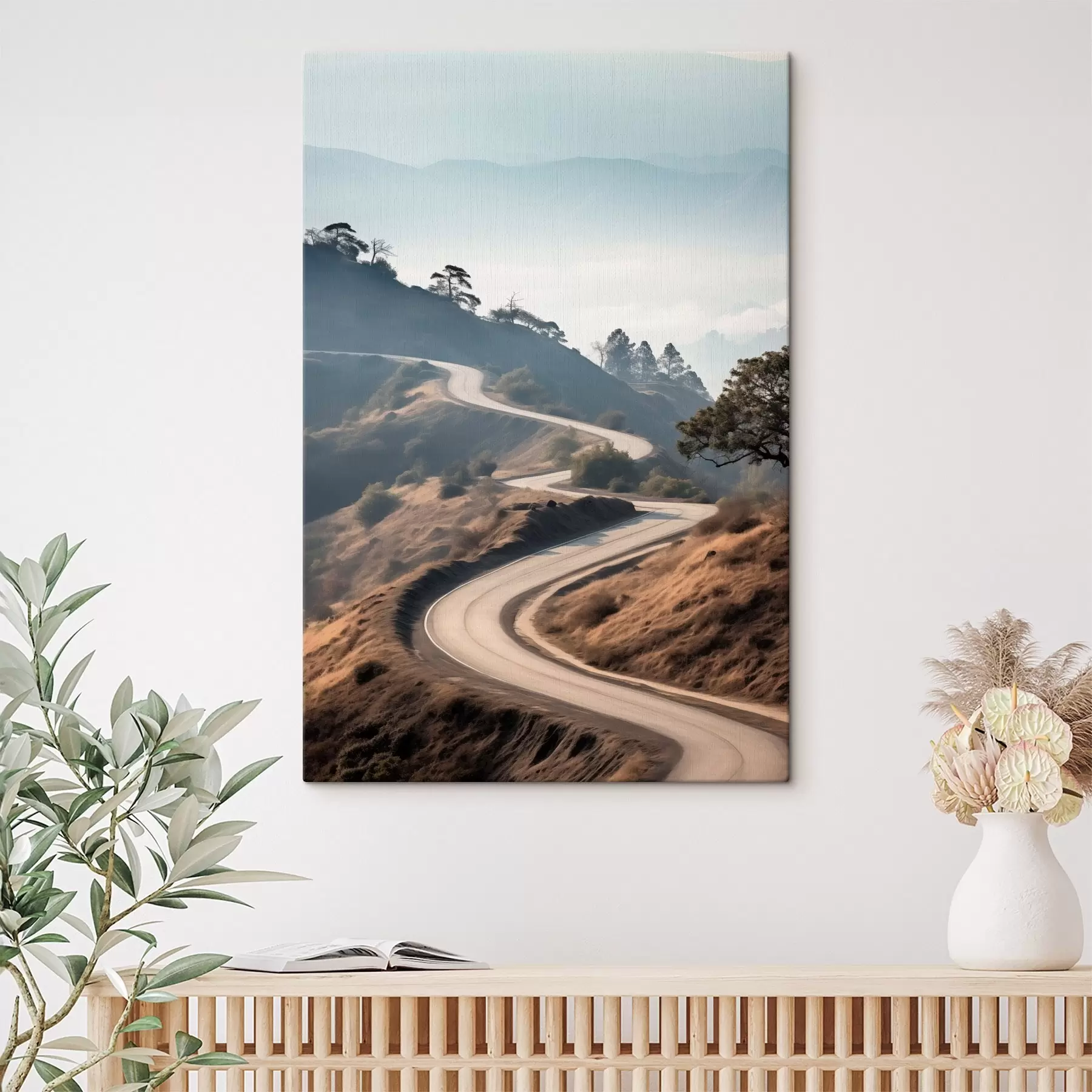 Obraz Kľukatá cesta cez kopcovitú krajinu so suchou trávou pod jasnou oblohou s horami v diaľke s46289