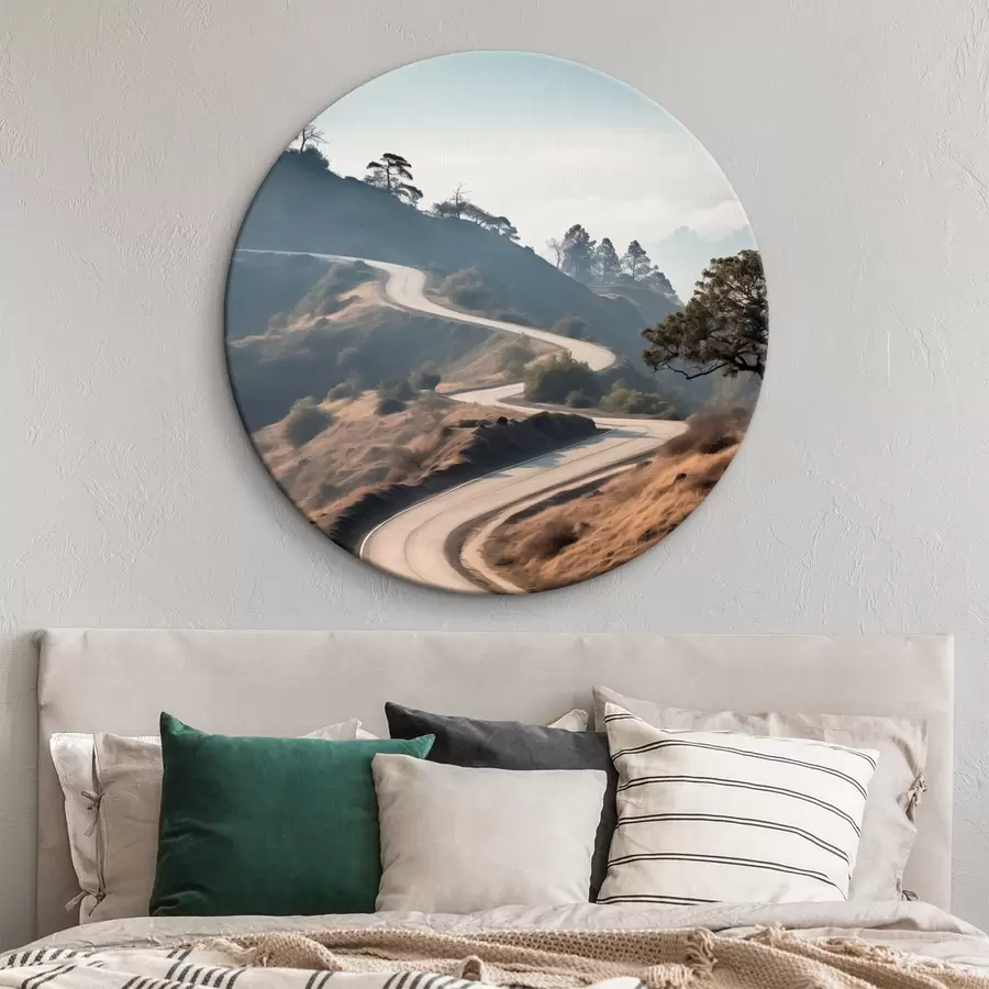 Obraz Kľukatá cesta cez kopcovitú krajinu so suchou trávou pod jasnou oblohou s horami v diaľke r46289