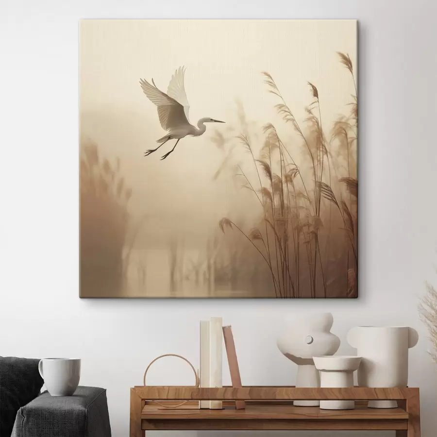 Obraz Nad jazerom lieta biela volavka, v pozadí ju obklopujú vysoké trstiny a stromy s48390